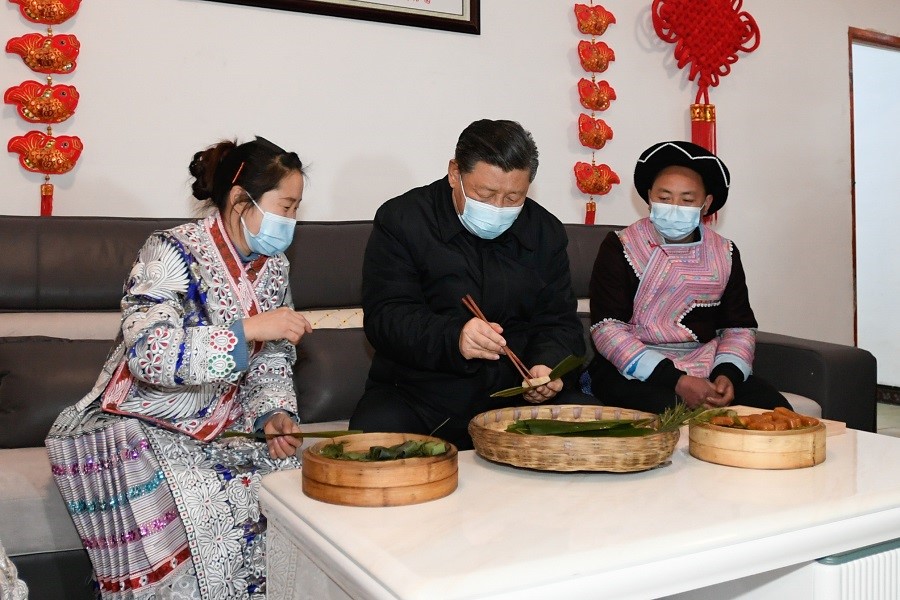 2021年2月3日下午，習近平在貴州畢節(jié)市黔西縣新仁苗族鄉(xiāng)化屋村苗族村民趙玉學家，同一家人邊聊家常邊制作當?shù)貍鹘y(tǒng)節(jié)日食品黃粑。新華社記者 李學仁 攝