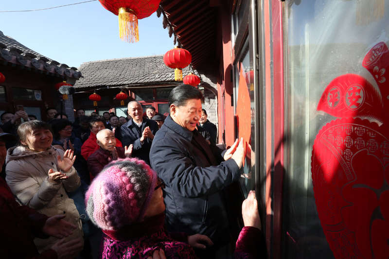 2019年2月1日上午，習近平在北京前門東區(qū)草廠四條胡同32號院，高興地拿起一幅“福”字，親自貼到門上，給這里的老街坊們拜年。新華社記者 鞠鵬 攝