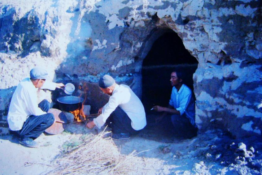 1983年，“六老漢”一代治沙人在“地窩子”生活做飯。新華社發(fā)（八步沙林場(chǎng)供圖）